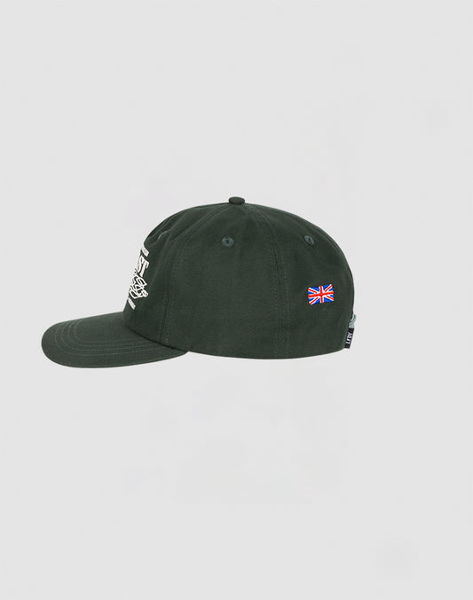 The LIVE FAST DIE YOUNG Live Fast Corporation Cap is a dark green 5-panel cap shown from the side, with a small embroidered UK flag on the back panel, a partially visible white Multi-Logo on the front, and a snap closure. Plain white background.