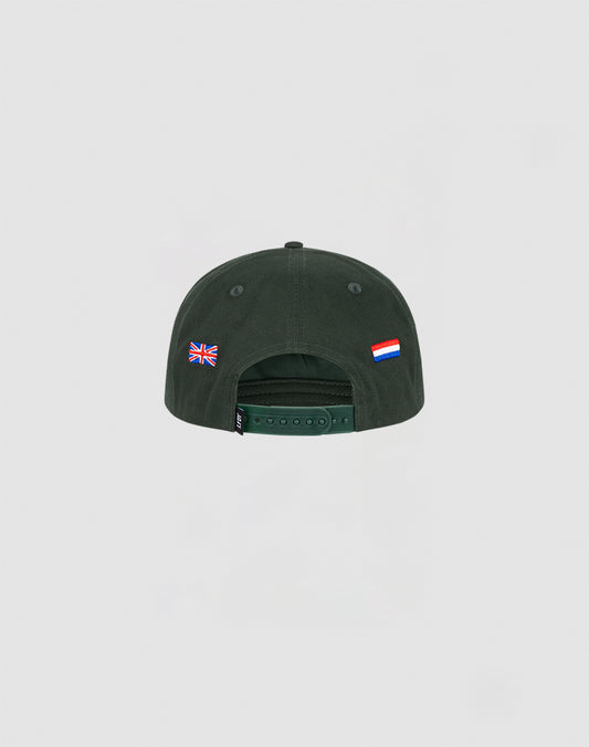 The Live Fast Corporation Cap by LIVE FAST DIE YOUNG is a dark green 5-panel hat, shown from the back with a UK flag on the left and a Netherlands-style flag on the right above the snap closure for a subtle multi-logo look.