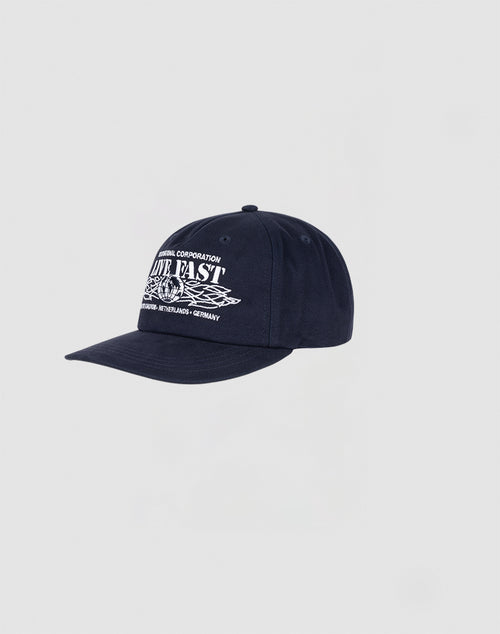 The Live Fast Corporation Cap by LIVE FAST DIE YOUNG is a navy blue, 100% cotton unstructured 5-panel hat with white multi-logo graphics and text on the front, shown against a plain light gray background.