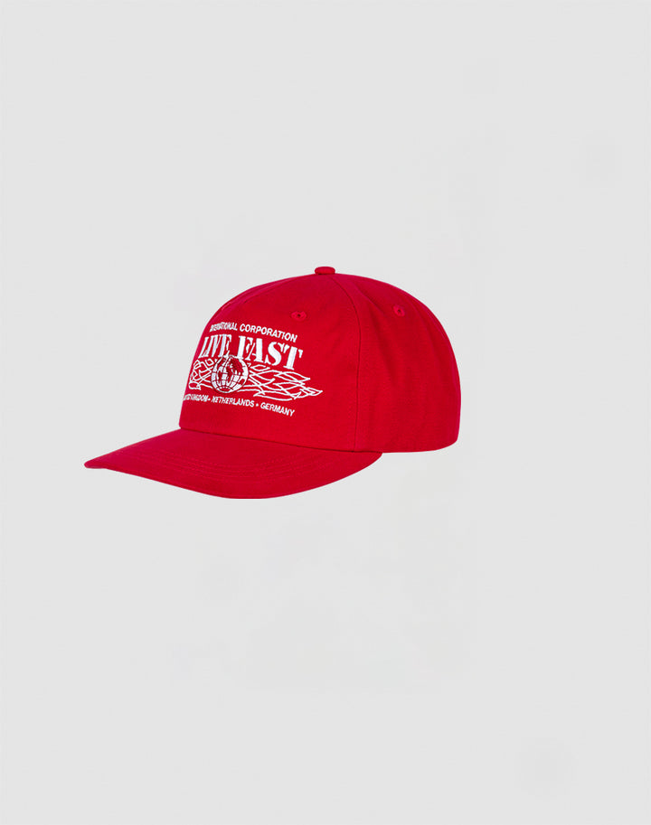 The Live Fast Corporation Cap by LIVE FAST DIE YOUNG is a bright red 100% cotton cap with white printed text, multi-logo graphics including Live Fast and checkered flags, plus a curved brim and button top.