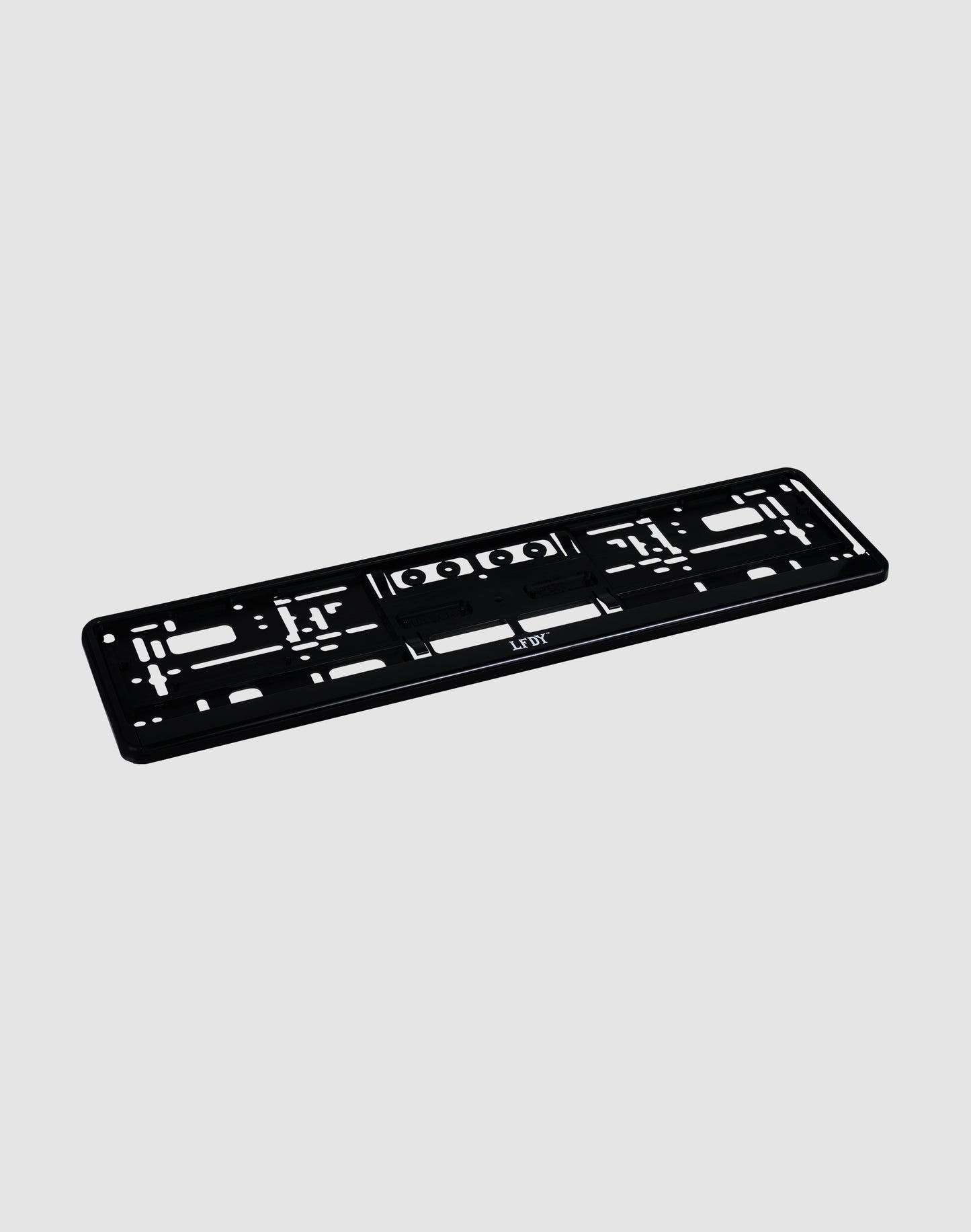 The LFDY License Plate Holder (2 Pack) by LIVE FAST DIE YOUNG is a black plastic Eurokennzeichen holder with multiple mounting slots and holes and a subtle LFDY logo, shown on a light gray background.