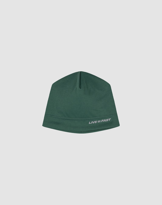 The Live Fast Performance Beanie by LIVE FAST DIE YOUNG is a fitted green hat featuring a small reflective white LIVE FAST logo print on the lower right, shown against a plain light gray background.