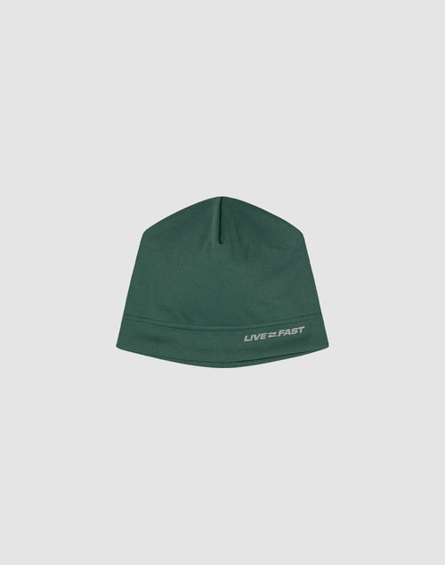 The Live Fast Performance Beanie by LIVE FAST DIE YOUNG is a fitted green hat featuring a small reflective white LIVE FAST logo print on the lower right, shown against a plain light gray background.