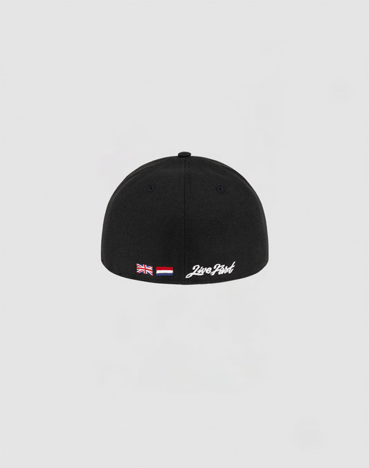 The LFDY x NEW ERA 59FIFTY Low Profile by LIVE FAST DIE YOUNG is a black fitted cap with British and Indonesian flag patches and white 2wo Point text above the back edge, shown against a plain light gray background.