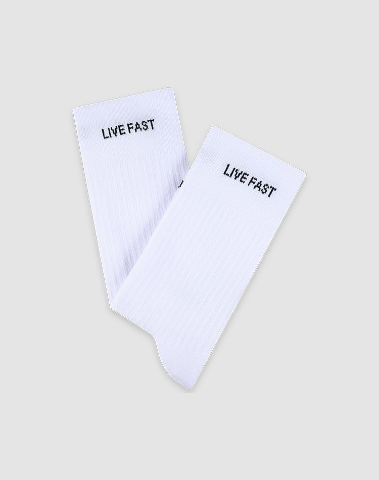 A pair of white LFDY Performance Socks by LIVE FAST DIE YOUNG, made from soft cotton and featuring "LIVE FAST" in black near the top, model LF2601-19869, shown on a light gray background.