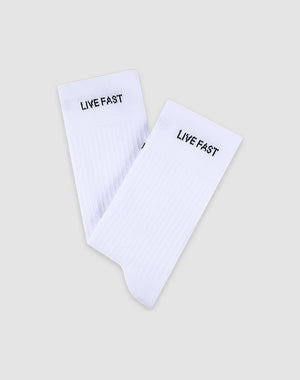A pair of white LFDY Performance Socks by LIVE FAST DIE YOUNG, made from soft cotton and featuring "LIVE FAST" in black near the top, model LF2601-19869, shown on a light gray background.