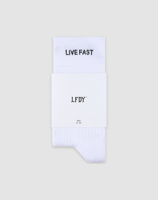 A pair of white LFDY Performance Socks by LIVE FAST DIE YOUNG featuring "LIVE FAST" in black on the cuff, with a white label showing LFDY, LF2601-19869, and size. Made from soft Baumwolle and set against a light grey background.