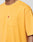 A person wearing the LIVE FAST DIE YOUNG LFDY Tube Pocket Tee, an oversized yellow cotton short-sleeve shirt with a chest pocket and small red tag; only their upper torso is visible.