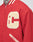 A close-up of the LFDY OC College Jacket, a red varsity style with a cream chenille “C” patch on the chest, striped trim on collar and pockets, and a glimpse of a tattooed neck above the collar.