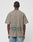 A person facing away wears the LIVE FAST DIE YOUNG Died for It Tee, a gray oversize vintage-effect T-shirt featuring colorful abstract human figures on the upper back and two circular blue/yellow designs near the hem, paired with light blue jeans.