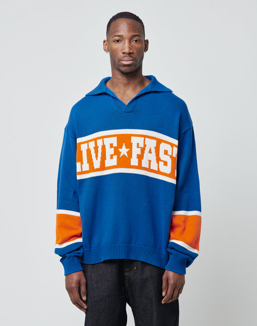 A person faces forward, wearing the LIVE FAST DIE YOUNG LFDY Knit Polo in blue, orange, and white with "LIVE FAST" across the chest and orange and white striped sleeves, displaying a neutral expression.