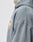 Close-up of a person wearing the LIVE FAST DIE YOUNG Lfdy & Sons Hooded Zip in gray, featuring an oversized fit and a small orange and white graphic with text on the left chest, focusing on the shoulder and chest area.