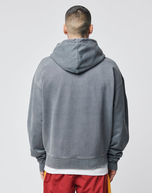A person with short hair and a neck tattoo is facing away from the camera, wearing the LIVE FAST DIE YOUNG Lfdy & Sons Hooded Zip in gray over a white shirt and red shorts with yellow stripes, against a plain light background.