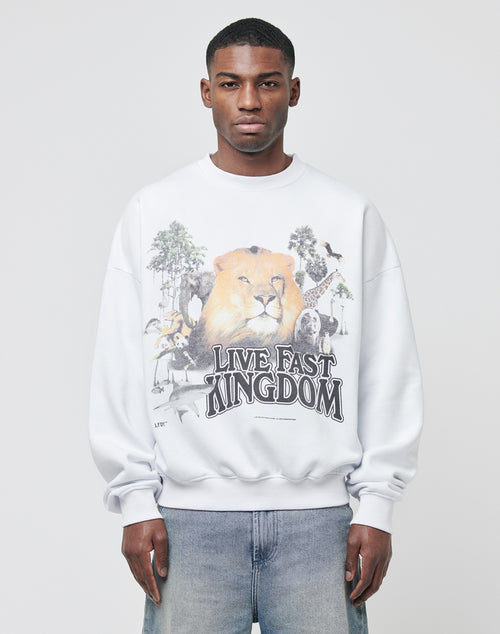 A person models the LFDY Vintage Lion Sweater, featuring an oversized fit and a vintage-style front print with a lion, animals, trees, and the text "LIVE FAST KINGDOM," set against a plain light gray background.