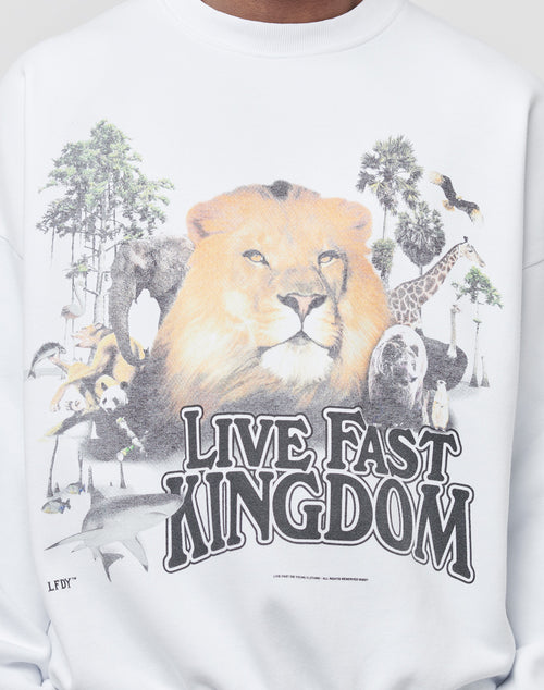 The LFDY Vintage Lion Sweater is a white oversized piece with a vintage look, featuring a bold front print of a large lion surrounded by animals and trees, and the LIVE FAST KINGDOM text beneath the artwork.