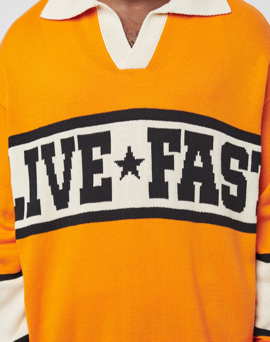 Wearing the LFDY Knit Polo by LIVE FAST DIE YOUNG—a bold orange and white oversized knit with stripes, a polo collar, black "LIVE FAST" text, and a star logo across the chest.