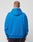A person with short hair stands with their back to the camera, wearing a bright blue Basic Chest Hooded by LIVE FAST DIE YOUNG and black pants against a plain light gray background.