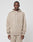 A man in the LIVE FAST DIE YOUNG Knit Hooded Zip, featuring a beige color, Kapuze mit Kordeln, and a small logo patch on the left chest, stands facing forward against a plain light background wearing matching beige pants.