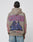 A person wears the LIVE FAST DIE YOUNG Godfathers Hooded in tan, an oversize fit with GODFATHERS in bold red and blue on the back, a vintage hooded figure by a church, “All rights RESERVED” text, and pairs it with blue jeans.
