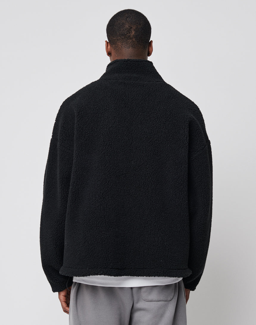 A person faces away from the camera, wearing an LFDY Oversize Teddy Jacket with a wide collar over a white shirt and gray pants, set against a plain light background.