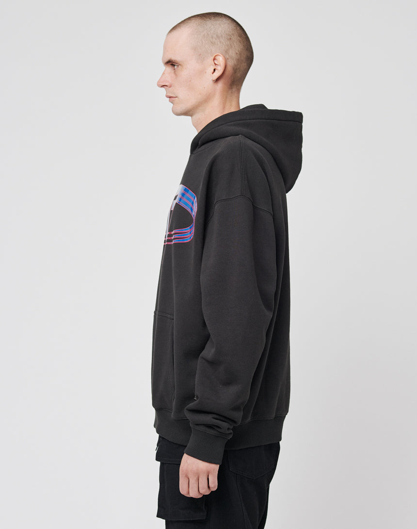 A person with a shaved head stands in profile against a plain background, wearing the LIVE FAST DIE YOUNG LF Circle Hooded black hoodie with a blue and red chest graphic and black shorts, made from weicher Baumwolle.