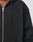 A close-up shows part of the chest and shoulder of a person wearing the LIVE FAST DIE YOUNG Waffle Hooded Zip, a black oversize fit hoodie made from waffle-textured material with drawstrings, a front pocket, and embossed logo text on the chest.
