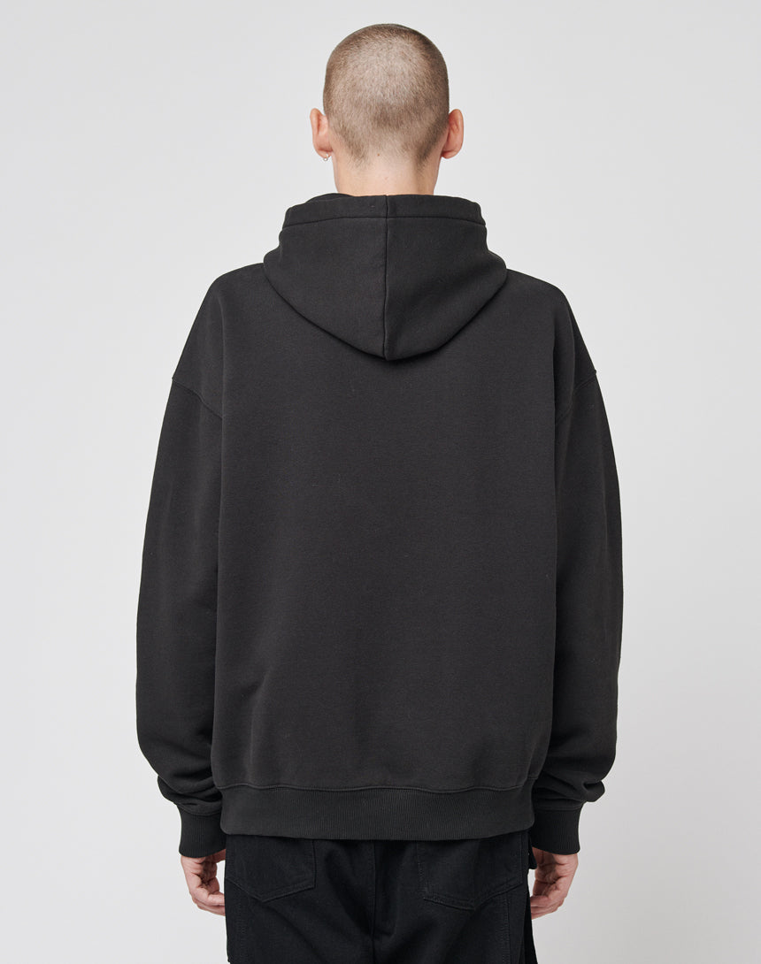 A person with a shaved head stands with their back to the camera, wearing a loose-fitting LF Circle Hooded by LIVE FAST DIE YOUNG and black pants against a plain light grey background.