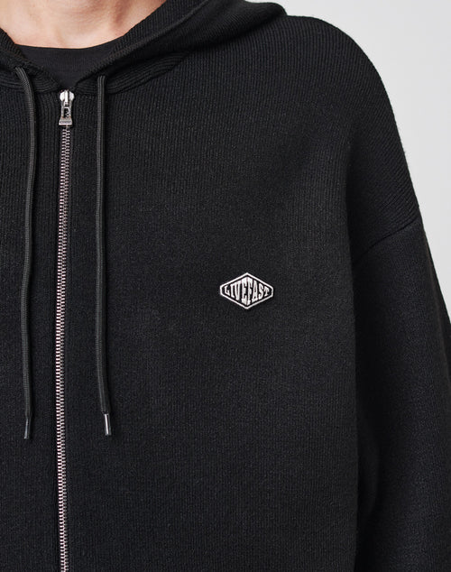 A close-up of the LIVE FAST DIE YOUNG Knit Hooded Zip, a black hoodie with zip, drawstrings, Kapuze, and a small diamond-shaped logo patch on the left chest.