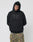 A model wears the LIVE FAST DIE YOUNG Live Fast Rhinestone Hooded, an oversized black hoodie with a rhinestone logo and LIVE FAST on the front, paired with camouflage pants, against a plain light gray background.