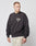A young man wears the LIVE FAST DIE YOUNG Live Fast Die Young Chest Sweater—an oversized black sweatshirt with a subtle chest print and vintage effect—paired with beige cargo pants, standing against a white background and looking left.