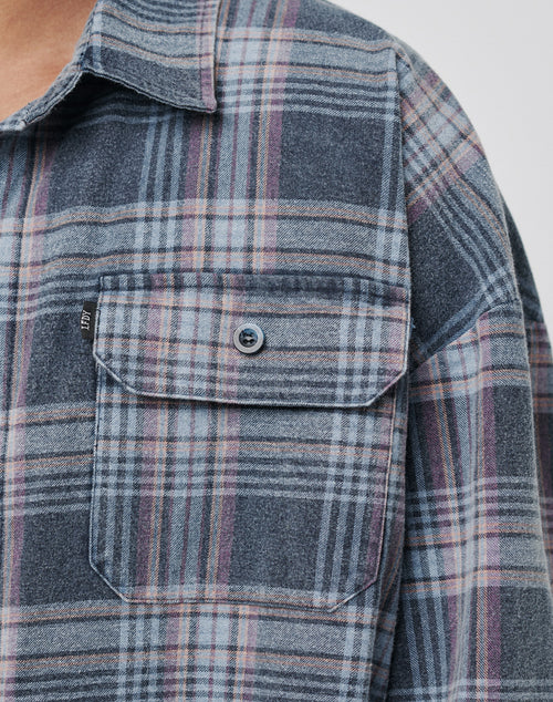 Close-up of the LIVE FAST DIE YOUNG Loose Flannel Shirt in blue, gray, and pink vintage wash, made from 100% Baumwolle, featuring a buttoned chest pocket with flap plus collar and shoulder details.