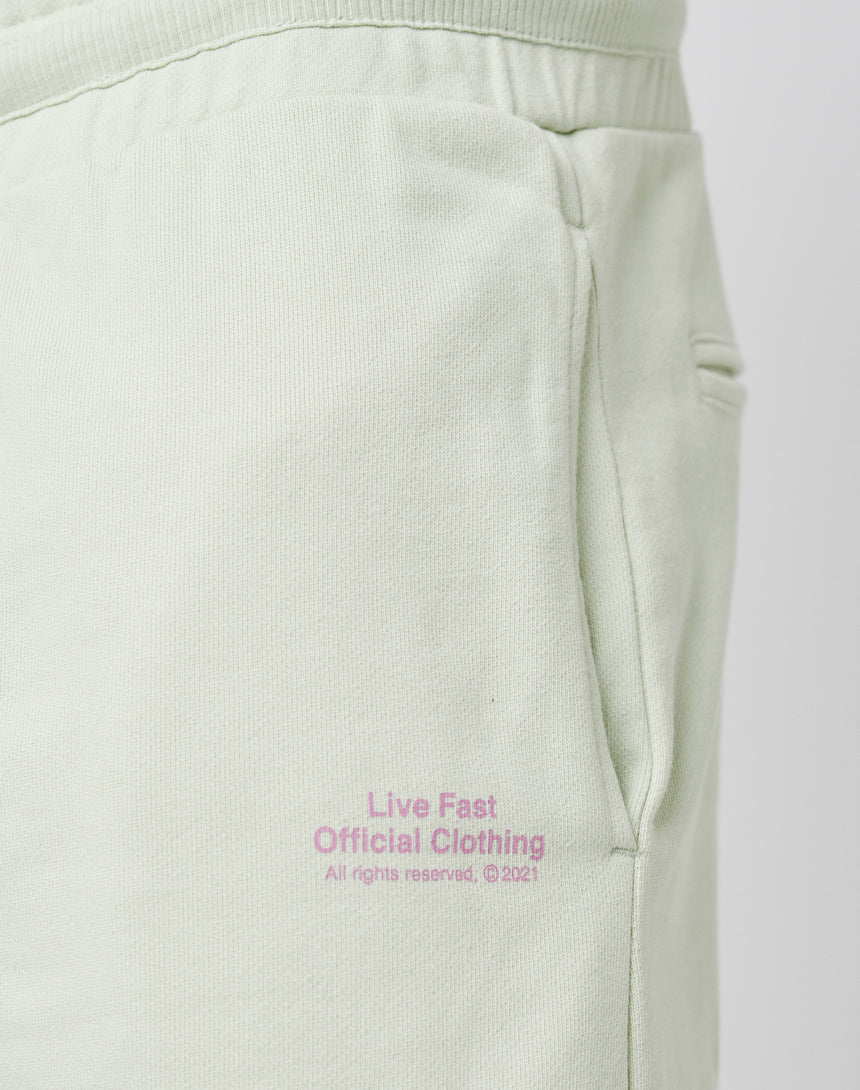 Close-up of the light green LFDY Official Jogger Regular Fit sweatpants featuring a side pocket and pink “Live Fast Official Clothing” text near the pocket. Front and back print, 100% cotton.
