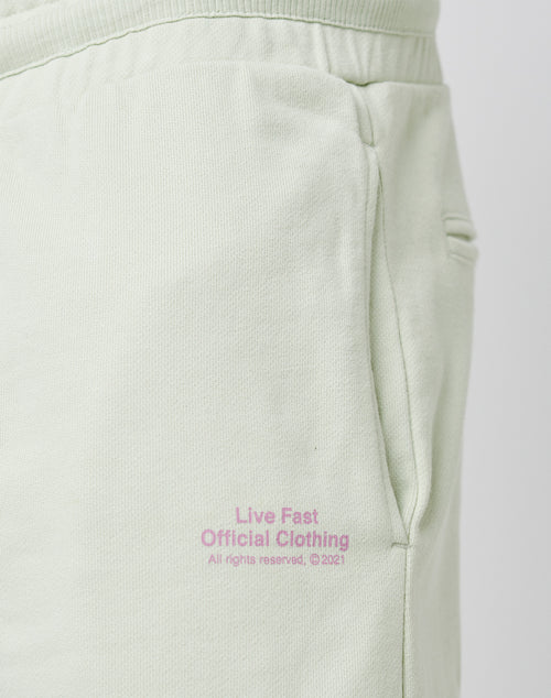 Close-up of the light green LFDY Official Jogger Regular Fit sweatpants featuring a side pocket and pink “Live Fast Official Clothing” text near the pocket. Front and back print, 100% cotton.