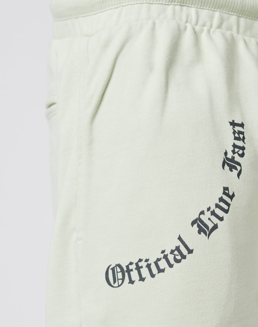 Close-up of light-colored LFDY Official Jogger sweatpants with pockets and "Official Live Fast" in black Gothic font on front and back. Made from 100% cotton for optimal comfort.