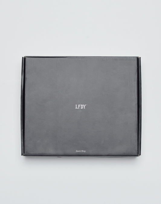 A closed, rectangular black box featuring LIVE FAST DIE YOUNG and Live Fast Swim Ring text on the front, placed against a plain white background.