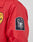 A close-up of a red LFDY Coach Jacket sleeve by LIVE FAST DIE YOUNG, regular fit and lightly padded, featuring two patches: a round yellow Safety County patch and a black-and-white eagle patch with the words Live Fast Die Young.