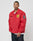 A man stands against a plain background wearing the LFDY Coach Jacket by LIVE FAST DIE YOUNG, in red with a regular fit and light padding. The jacket features a yellow circular patch on the left chest and a black-and-white patch on the right sleeve.