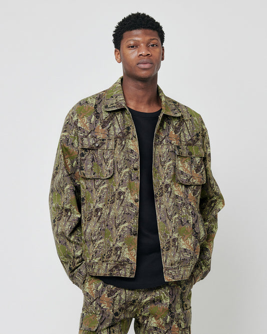 A man stands facing the camera with his hands in his pockets, wearing a LIVE FAST DIE YOUNG LFDY Hunter Jacket and matching pants made from 100% cotton, set against a plain light gray background.