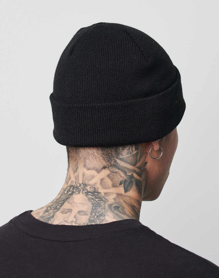 A person is shown from behind wearing an LFDY Beanie by LFDY and a Regular Fit black shirt. They have neck tattoos, including a detailed face and rose, and wear a hoop earring in their left ear.