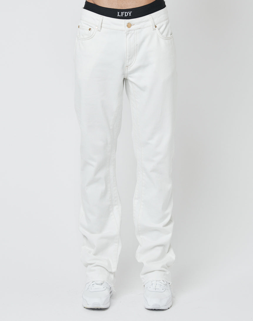 A person wears LFDY Striped Flared Denim in white, styled with white sneakers and a visible black LFDY waistband against a plain white background.