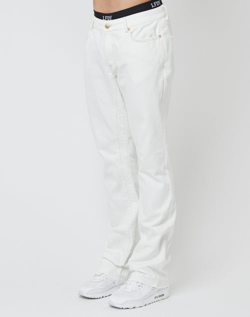 A person wears LFDY Striped Flared Denim and a black LFDY waistband, paired with white sneakers, standing against a plain white background. The upper body is not visible.