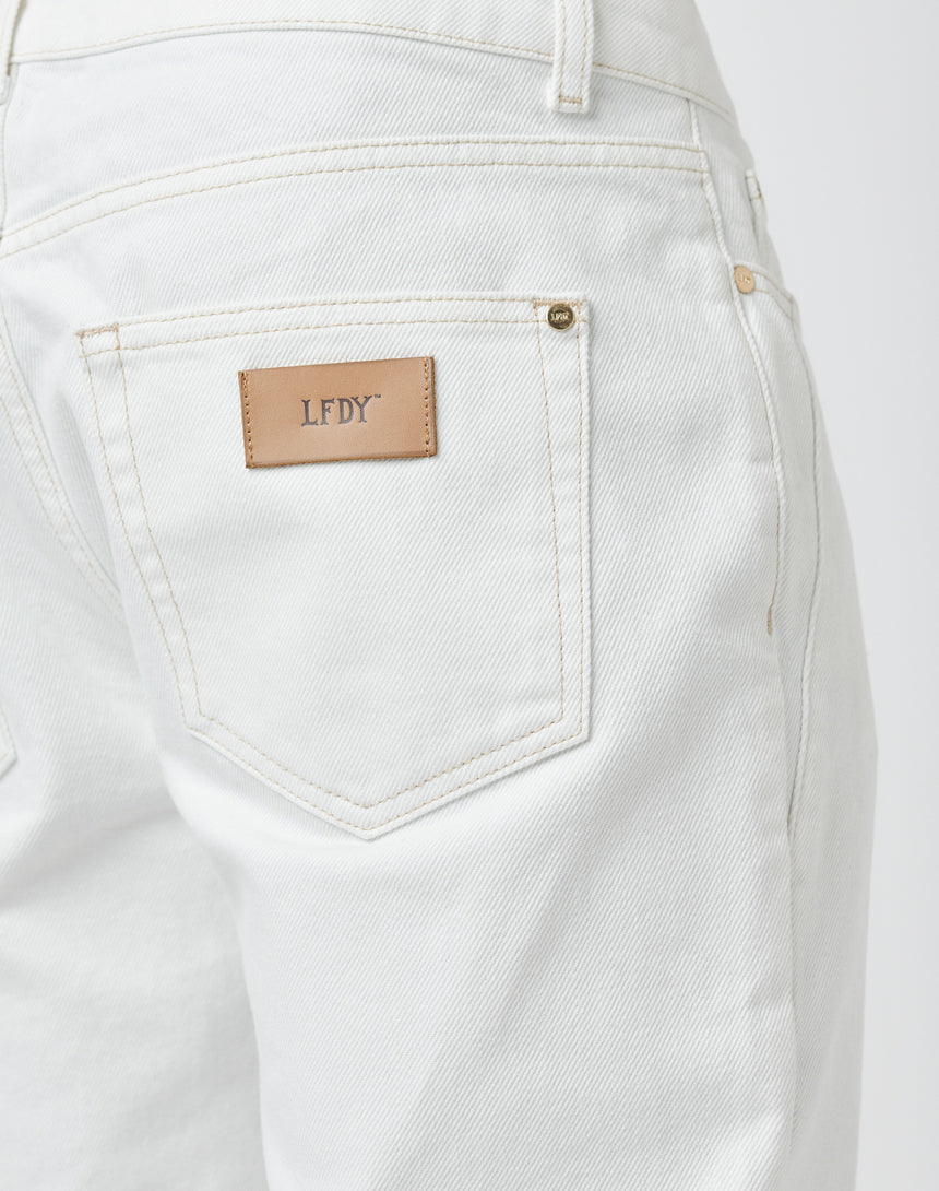 Close-up of the back pocket on Striped Flared Denim by LFDY, featuring visible neat stitching and a tan leather patch above the pocket embossed with the brand name in gold letters.