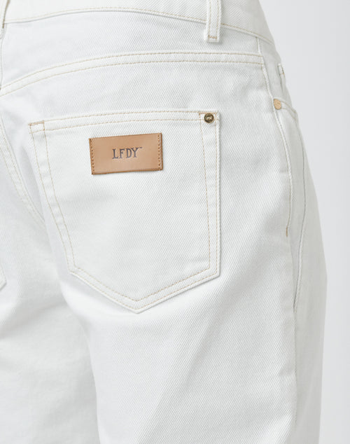 Close-up of the back pocket on Striped Flared Denim by LFDY, featuring visible neat stitching and a tan leather patch above the pocket embossed with the brand name in gold letters.