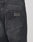 Close-up of the back pocket on LIVE FAST DIE YOUNG Regular Denim jeans. The black 100% cotton denim shows a worn texture, and a rectangular Lederpatch with LFDT is embossed above the pocket.