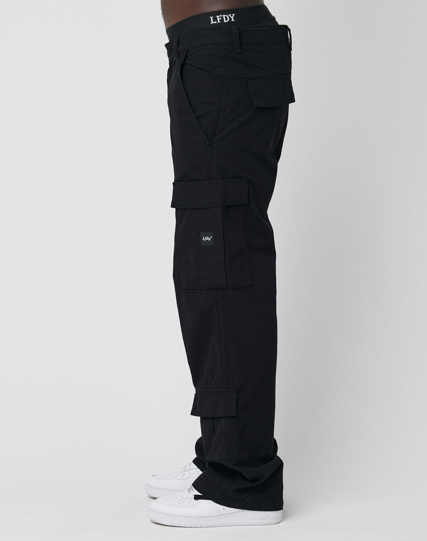 A person is wearing black LFDY Wide Summer Cargo pants with multiple pockets and white sneakers, standing sideways against a plain white background. The waistband features the LFDY logo.