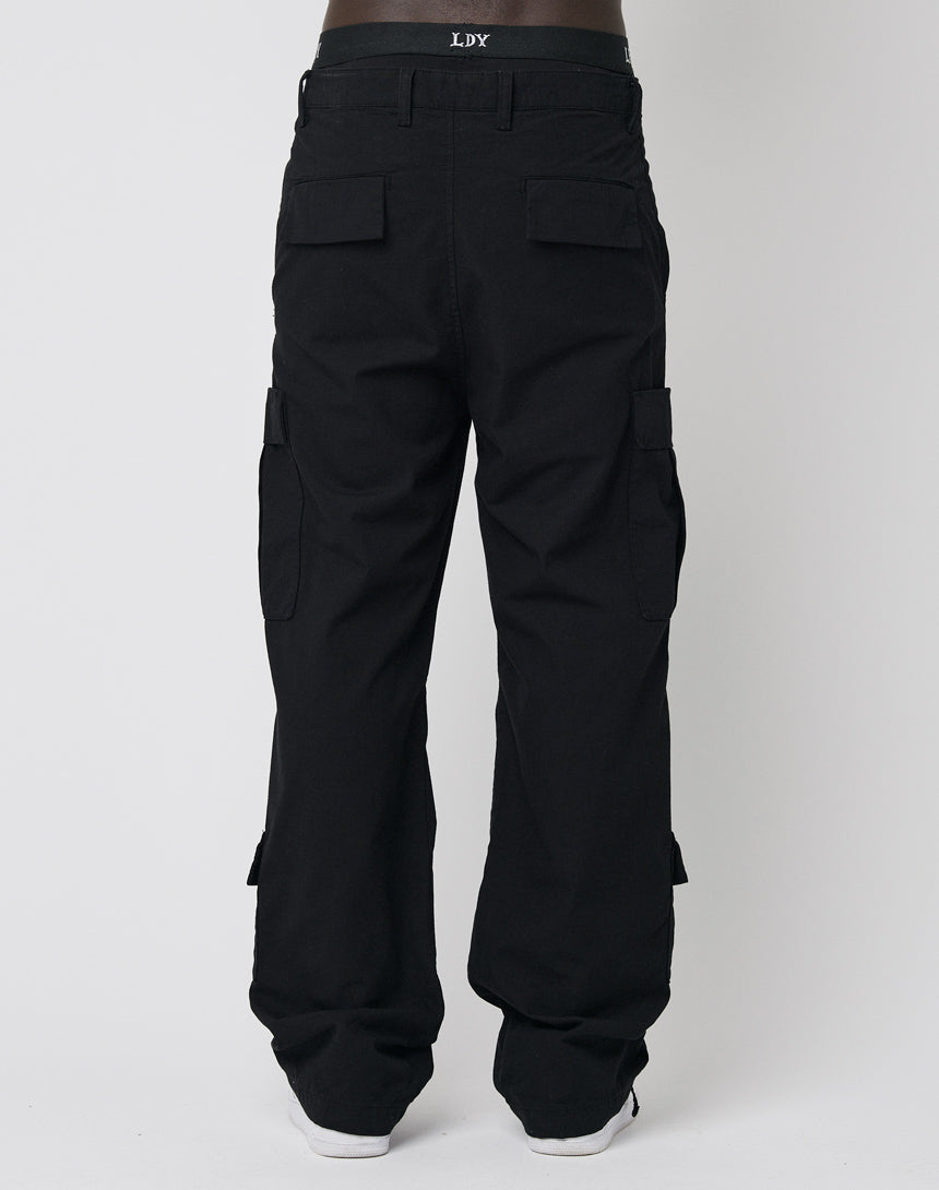 A person models the LFDY Wide Summer Cargo, featuring a wide fit and multiple flap pockets, standing with their back to the camera against a plain white background.